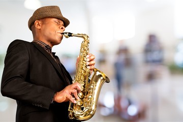 Close-up man playing on saxophone on background
