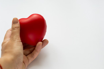 Fototapeta premium Close up red heart symbol of love isolated on white backgroound. Hand holds red heart. St. Valentines day. Objecr photography. Health and cardiovascular risk of diseases. Cardiology news. 