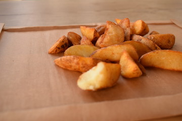 appetizing juicy golden potato slices on a wooden tray