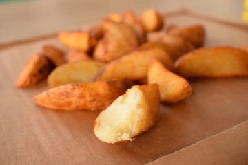 appetizing juicy golden potato slices on a wooden tray