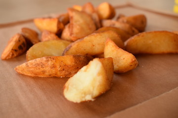 appetizing juicy golden potato slices on a wooden tray