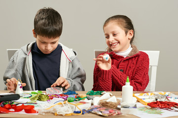 Fototapeta premium Childrens making decorations for new year holiday. Painting watercolors. Top view. Artwork workplace with creative accessories.