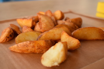 appetizing juicy golden potato slices on a wooden tray