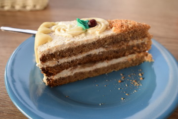 an appetizing slice of a pie made of banana and chocolate with a blue leaf on top and a cranberry on an emerald plate