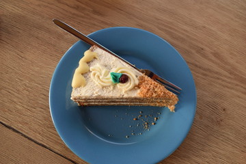 an appetizing slice of a pie made of banana and chocolate with a blue leaf on top and a cranberry on an emerald plate