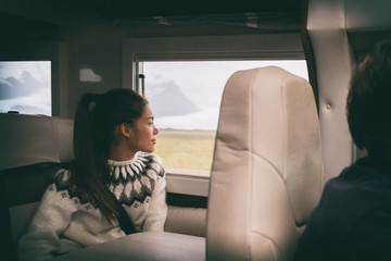 RV camper van travel Asian girl sitting in back of motorhome car on Iceland road trip. Europe...