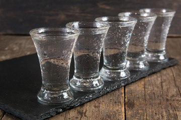 russian vodka in shot glasses on a dark wooden background