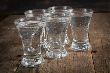 russian vodka in shot glasses on a dark wooden background