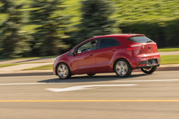 Obraz na płótnie Canvas Speeding red mini hatchback