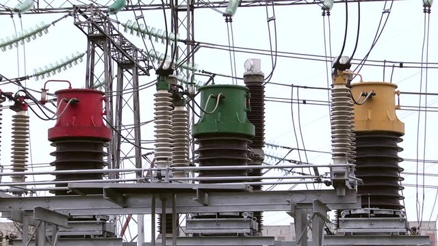 Electrical poles with wires and insulators at the electrical substation. Circuit breaker high voltage.  Part of high-voltage substation with switches and disconnectors.