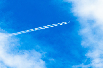 Flight over the city. Clear blue sky is cut by the plane. Height. Flight. Power and might.