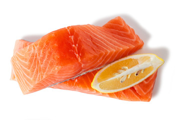 Raw salmon fillets with lemon, isolated on white background. Top view.