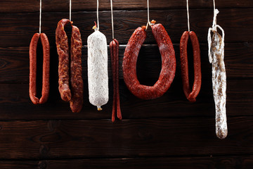sausages hang from a rack at market. Country dark style. Traditional food. Smoked sausages meat...