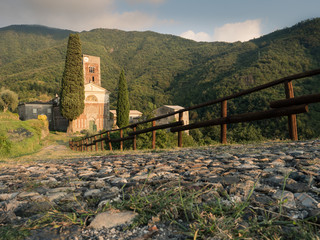 Fototapeta na wymiar Abbazia di Sant'Andrea di Borzone Liguria, Diocesi Chiavari - Genova, al tramonto, con risseu - rissêu - acciottolato 