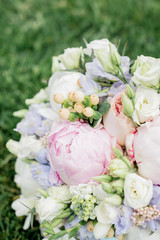 Beautiful wedding bouquet of peonies on the background of grass