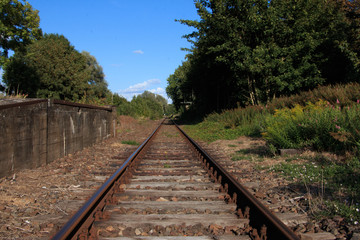 Fototapeta na wymiar single train track on lost places trainstation