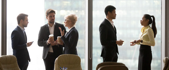Multiracial, business people talking in break, drink coffee, standing near window. Asian and african, american colleagues standing separately. Coworking, teamwork  wide image - obrazy, fototapety, plakaty