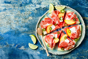 Fresh summer watermelon pizza with feta cheese, peach, prosciutto, jalapeno and honey drizzle on...