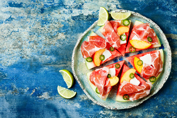 Fresh summer watermelon pizza with feta cheese, peach, prosciutto, jalapeno and honey drizzle on...