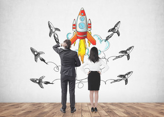 Obraz premium Confused business people looking at startup rocket