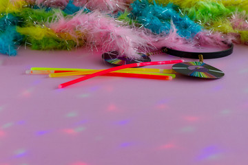 Neon Party supplies, props  and  Colorful Feather Boas on pink background. Colored led party lights - Photo booth Props. Copy Space. Party background