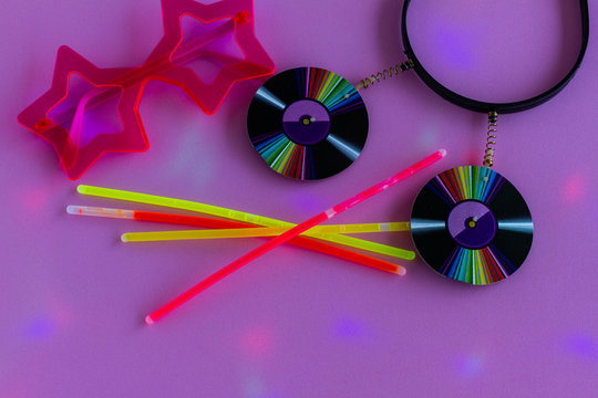 Neon Party Supplies  And Props On Pink Background. Colored Led Party Lights - Photo Booth Props. Copy Space. Top View. Party Background