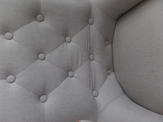Close up image of a grey brown upholstered chair