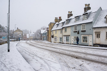 Cambridge, UK -  10 December 2017. UK Weather: Heavy snow in Cambridge, England,  UK with empty road covered in white snow.
