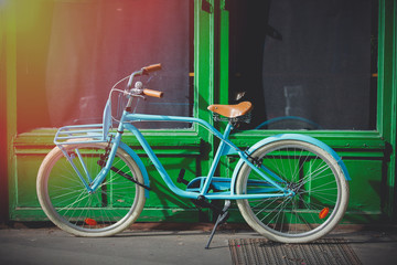 Fototapeta na wymiar Old blue bike near green house on street of Strasburg, France