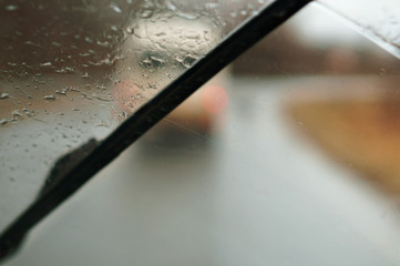 Raindrops on the car window. The road is wet with rain. Rainy weather.