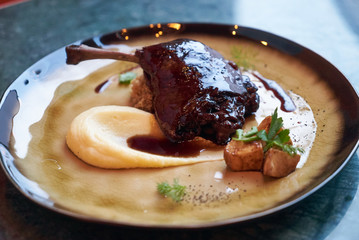 Duck confit with Quinoa puree, celery, apple with cinnamon sauce served on plate. Exclusive restaurant meals