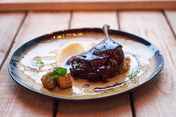 Duck confit with Quinoa puree, celery, apple with cinnamon sauce served on plate. Exclusive restaurant meals