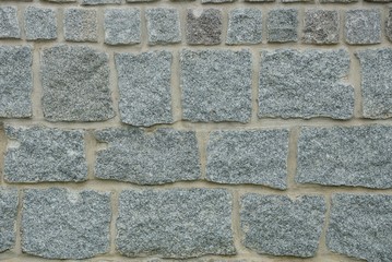 gray stone texture of large cobblestones in a concrete fence wall