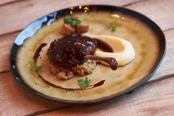 Duck confit with Quinoa puree, celery, apple with cinnamon sauce served on plate. Exclusive restaurant meals