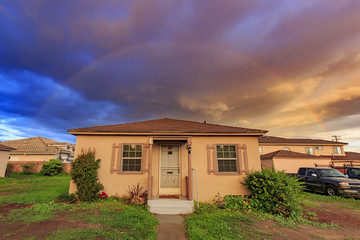 Exterior view of a home with stunning clouds and rainbow
