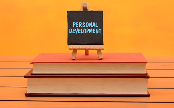 Personal development theme with empty books on wooden background