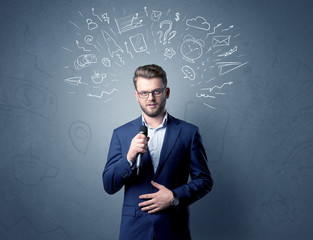 Businessman speaking into microphone with mixed doodles over his head