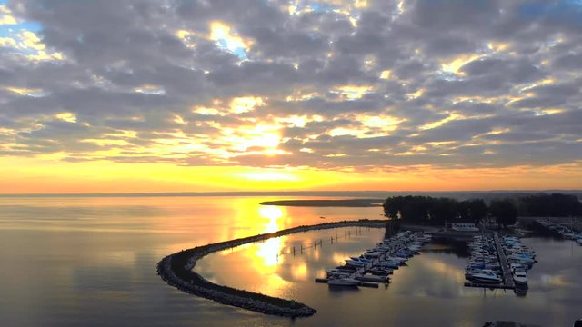 Amazing dawn sky over bay with tranquil waters, marina, aerial view.
