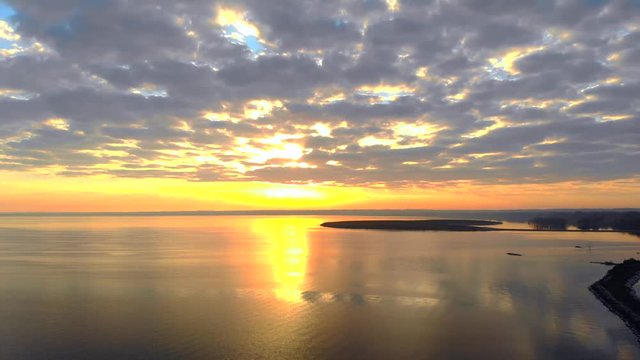 Amazing dawn sky over bay of tranquil waters, aerial view.
