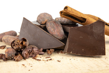 Tasty dark chocolate and cocoa beans on a white table. Sweets used to prepare desserts in the kitchen.