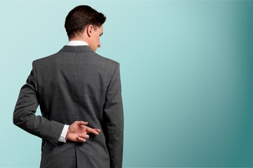 Businessman with his fingers crossed behind his back - concept