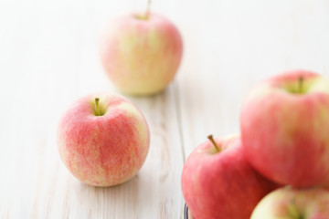 Freshly picked organic light pink apples. White wooden table, high resolution.