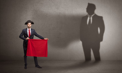 Businessman standing with red cloth on his hand and his shadow on the background
