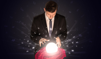 Gorgeous businessman looking to inspiration in a magic ball in his lap and doodle concept
