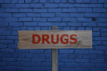 Drugs sign on wall background for addiction concept.