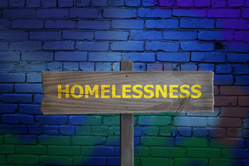 Homelessness sign on graffiti street background.