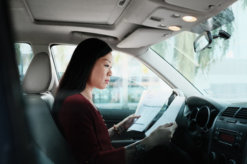 Busy Chinese Business Woman Working In Car With Papers