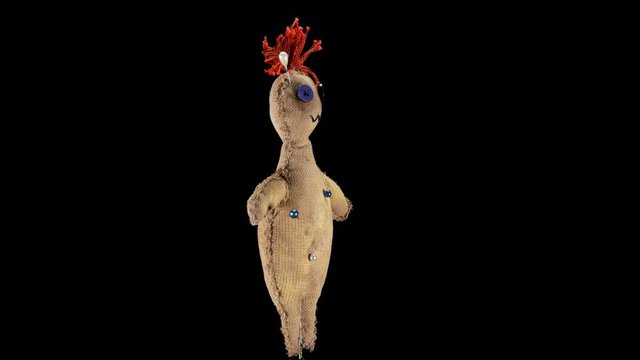 a voodoo doll that is used for rituals, rotates, close-ups