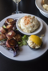 Grilled Bacon Wrapped Scallops Served With Coleslaw and Creamy Potato Salad