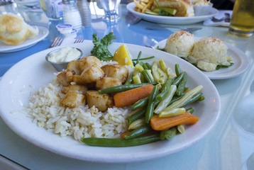 Cooked Scallops Served with Beans and Baby Carrots on a Bed of Rice, with Side of Creamy Potato Salad